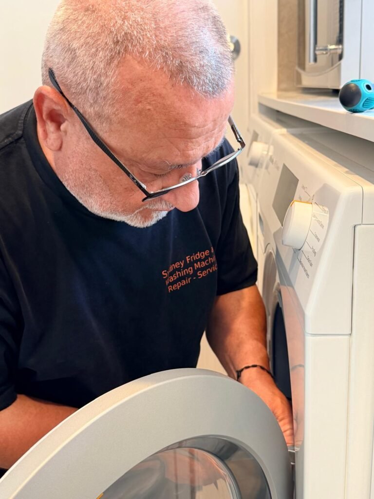 Technician checking the door lock of a front-loader washing machine during a repair